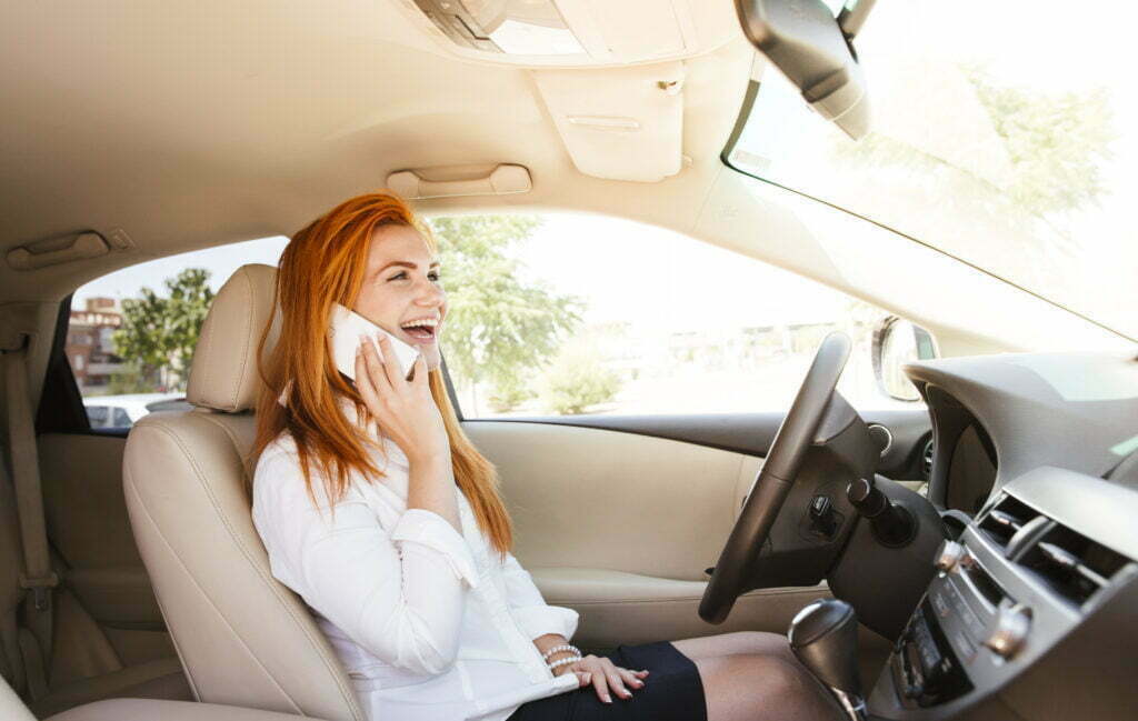 happy business woman using her smartphone in a car 2022 12 16 22 36 28 utc