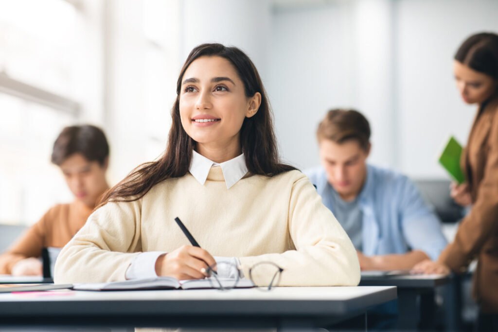 smiling student sitting at desk in classroom think 2022 12 16 08 56 54 utc
