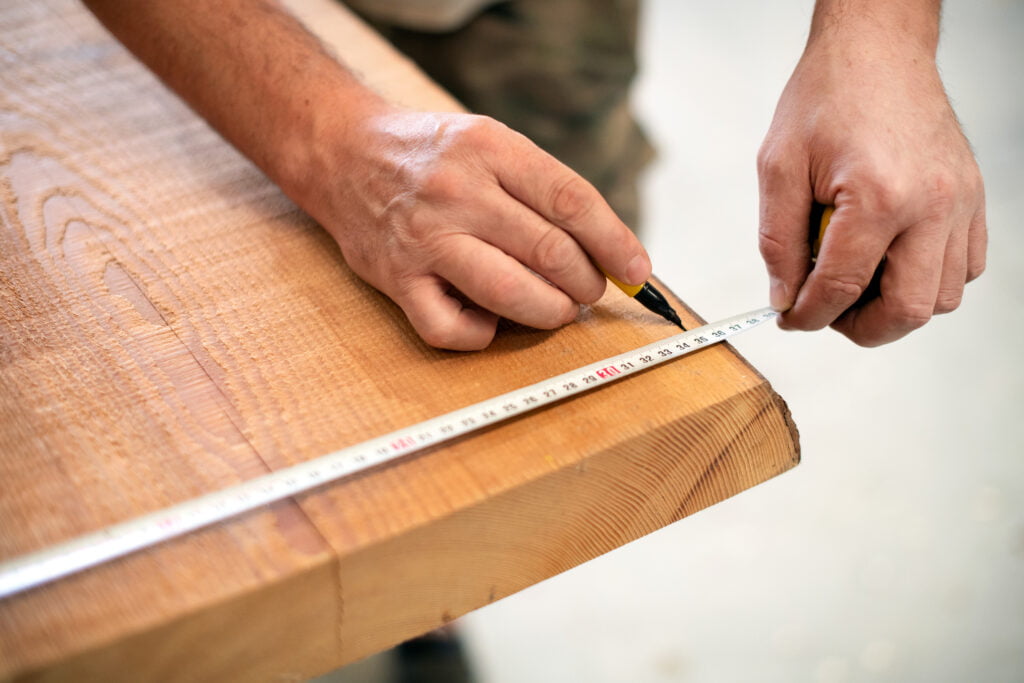 carpenter measuring a wooden plank 2021 08 26 22 34 33 utc